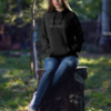 mockup-of-a-woman-wearing-a-hoodie-while-sitting-on-a-lodge-in-the-woods-2794-el1